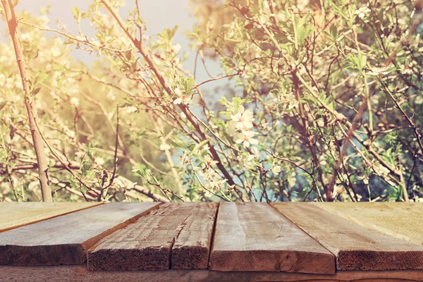 Wooden rustic table in front of spring cherry tree — Stock Photo, Image