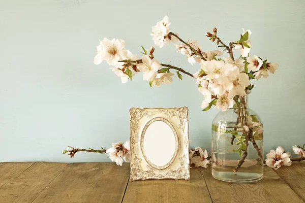 Vintage leerer Fotorahmen neben Frühlingsblumen — Stockfoto