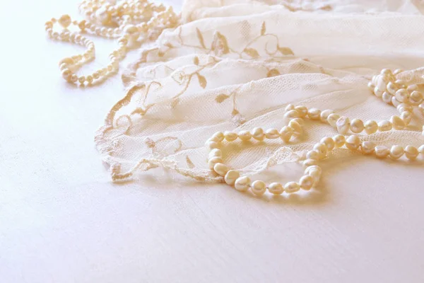 Background of white delicate lace fabric and pearls. — Stock Photo, Image