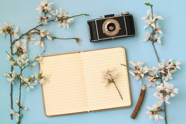Třešňové květy strom, otevřené prázdný poznámkového bloku a starý fotoaparát — Stock fotografie