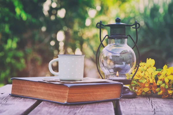 Vintage oriental lantern next to book over wooden table — Stock Photo, Image