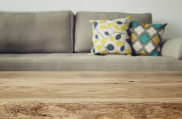 Mesa vacía de madera frente al sofá interior de la sala de estar — Foto de Stock