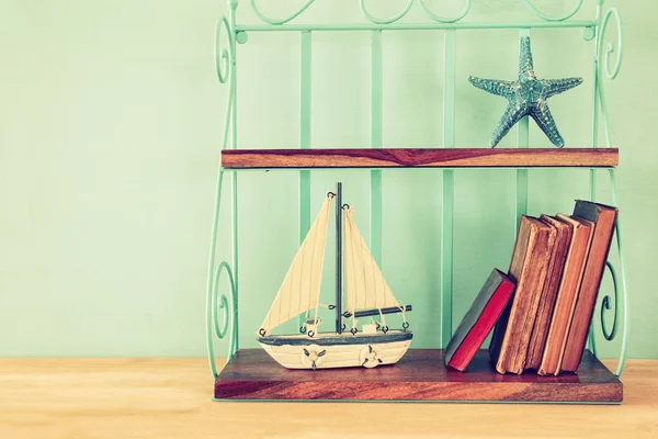 Vintage Regal mit Boot, alten Büchern und Seesternen — Stockfoto