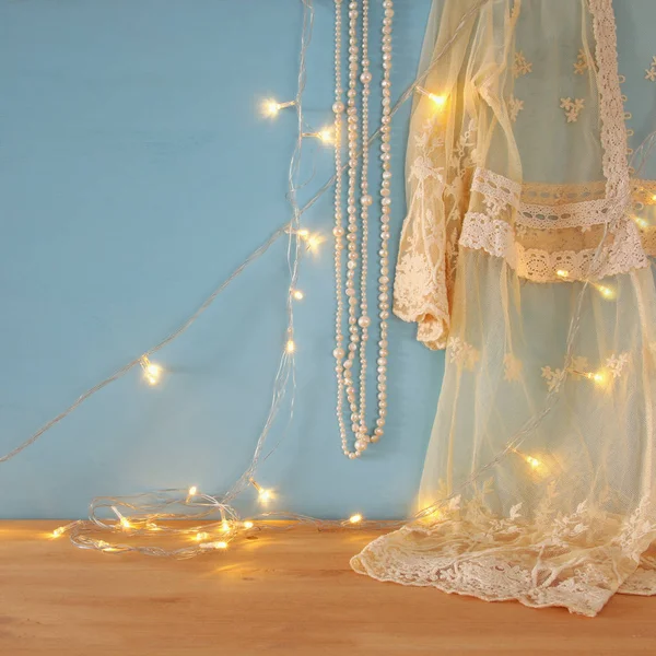 Top de renda de crochê branco vintage, pérolas e luzes de guirlanda quente — Fotografia de Stock