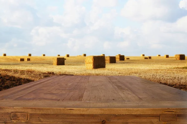 Dřevěné desce stole pole pšenice seno bale — Stock fotografie