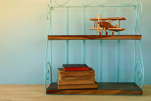 Scaffale vintage con vecchio giocattolo aereo in legno e libri — Foto Stock