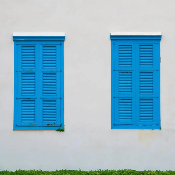 Wall of old building and blue windows with shutters — Stock Photo, Image