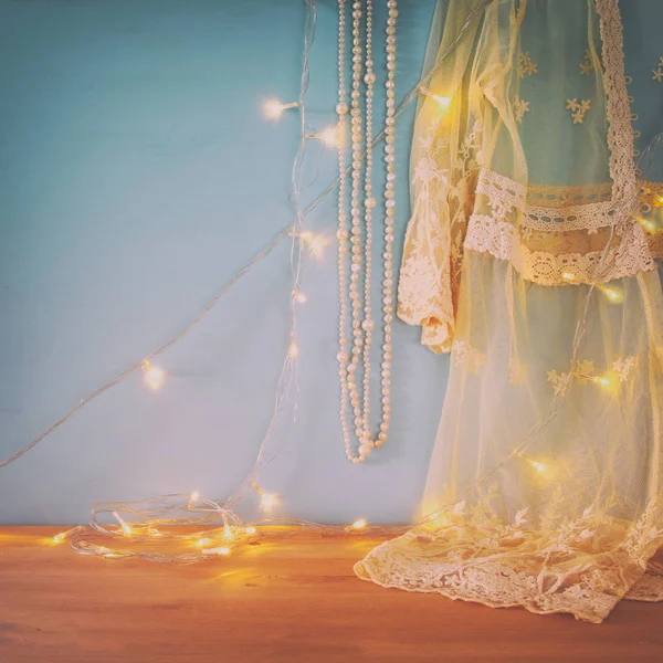 Biały top z koronki, perły i świateł girlanda ciepłe na szydełku — Zdjęcie stockowe