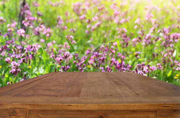 Table rustique en bois devant les fleurs du printemps — Photo