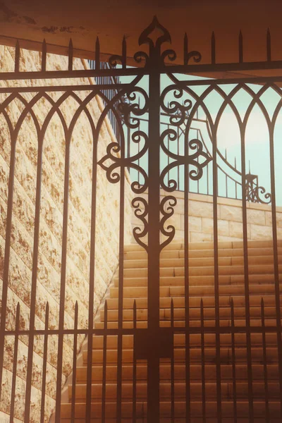 Obrázek staré kamenné schodiště za zavřenou bránou — Stock fotografie