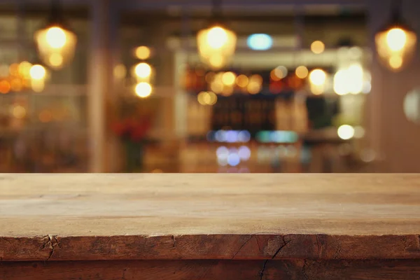 Mesa de madera frente a las luces abstractas del restaurante fondo — Foto de Stock