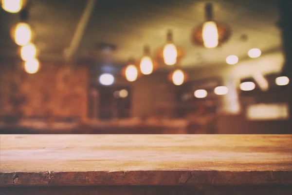 Houten tafel voor abstracte restaurant lichten achtergrond — Stockfoto
