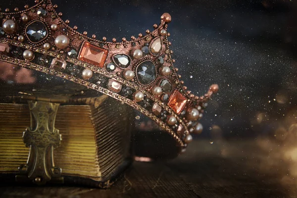 low key image of beautiful queen/king crown on old book