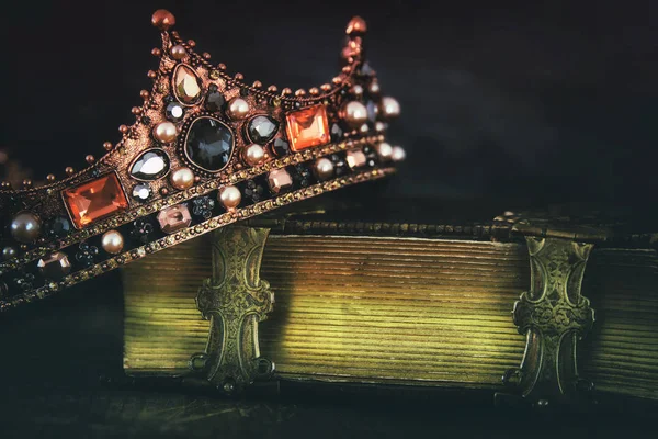 low key image of beautiful queen/king crown on old book