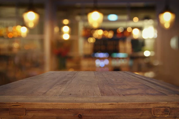 Mesa de madera frente a las luces abstractas del restaurante fondo — Foto de Stock