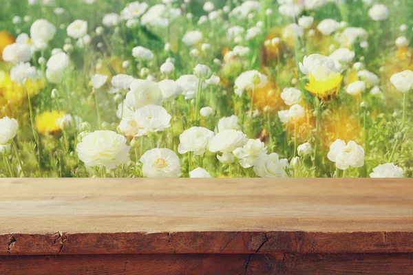 Träskiva bordet framför sommaren blommor fält — Stockfoto