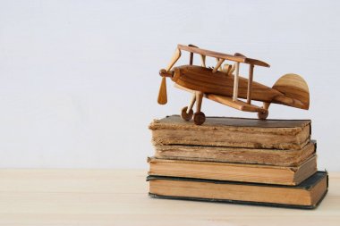ahşap masa üzerinde uçak oyuncak yanındaki eski kitaplar
