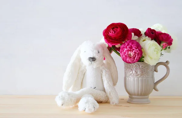 Rosas en el jarrón vintage y divertido conejito esponjoso —  Fotos de Stock