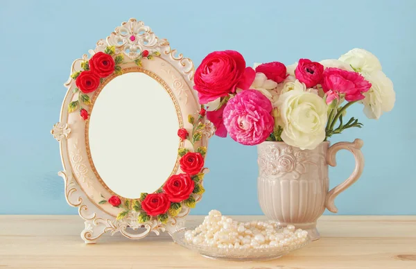 Flores de primavera y perlas junto al marco de fotos vintage en blanco — Foto de Stock