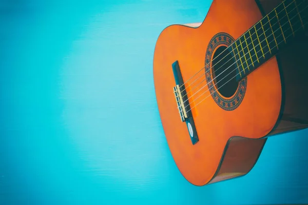 Close up of acoustic guitar against a wooden background — Stock Photo, Image