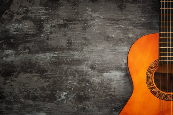 Close up of acoustic guitar against a wooden background — Stock Photo, Image