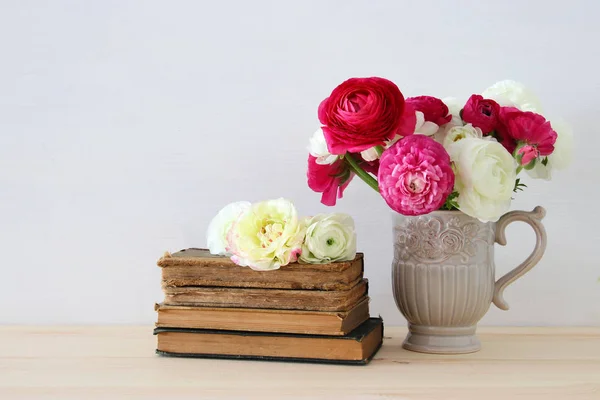 Hermoso ramo de flores en el jarrón junto a libros antiguos —  Fotos de Stock
