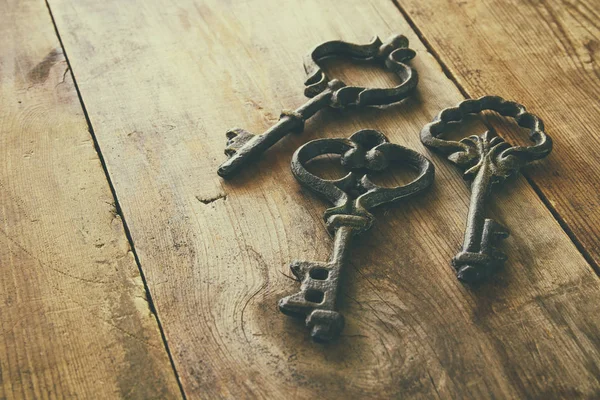 Image of antique keys on old wooden table