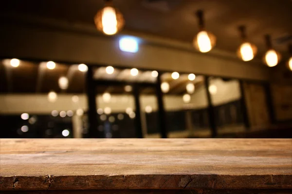 Mesa de madera frente a las luces abstractas del restaurante fondo —  Fotos de Stock