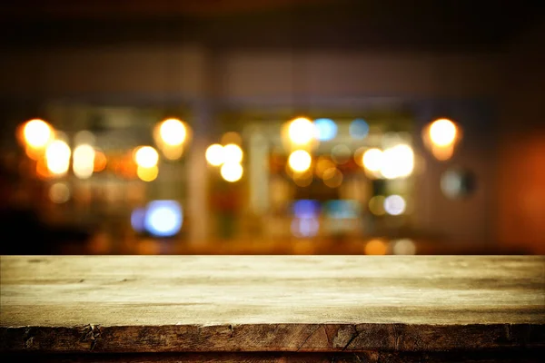 나무 테이블 앞에 추상의 흐리게 레스토랑 조명 — 스톡 사진