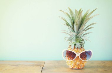 Ananas masanın üzerine güneş gözlüklü. Plaj ve tropikal Tema.