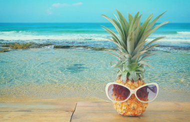 Ananas masanın üzerine güneş gözlüklü. Plaj ve tropikal Tema.