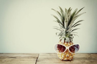 Ananas masanın üzerine güneş gözlüklü. Plaj ve tropikal Tema.