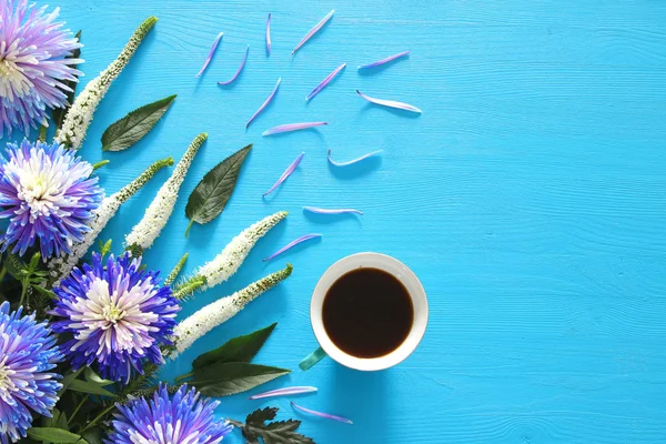 Cup of coffee and beautiful blue and white flowers arrangement — Stock Photo, Image