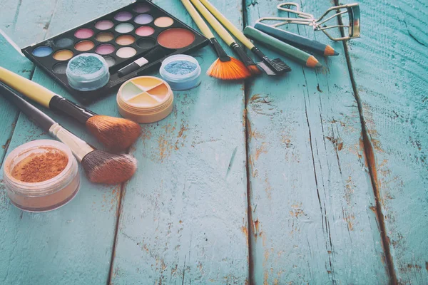 Trucco cosmetici strumenti di bellezza e spazzole su sfondo di legno — Foto Stock