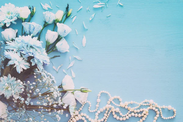 Вид зверху на красиві і ніжні сині квіти розташування поруч з перлами намисто — стокове фото