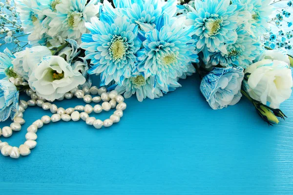 Вид зверху на красиві і ніжні сині квіти розташування поруч з перлами намисто — стокове фото