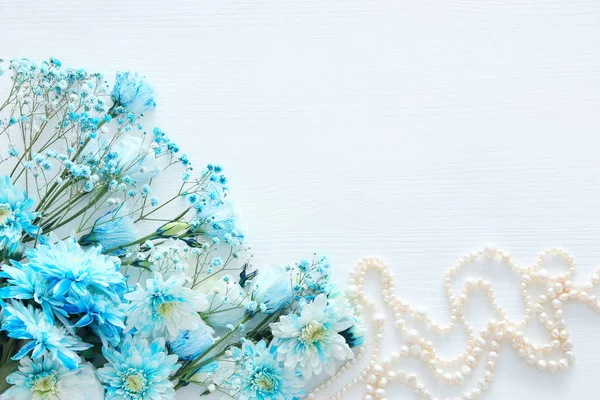 İnci kolye yanında güzel ve narin mavi çiçekler düzenlemenin Üstten Görünüm — Stok fotoğraf