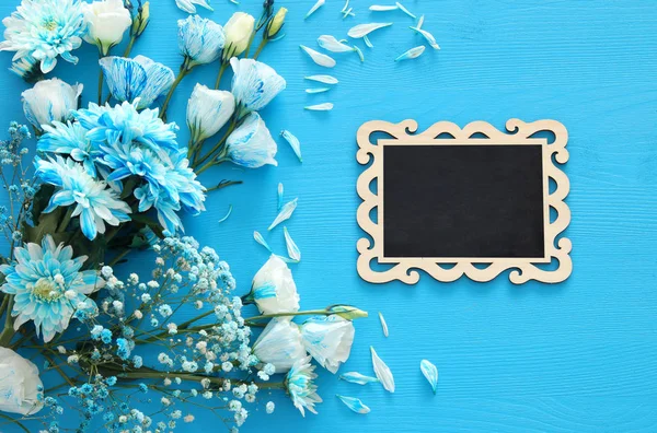 Belo arranjo de flores azuis e quadro negro — Fotografia de Stock