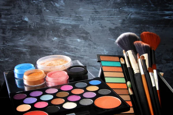 Maquillage cosmétiques outils de beauté et brosses devant de fond en bois noir — Photo
