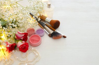 makyaj ve parfüm ahşap arka plan üzerinde yanında güzel güller.