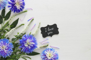 mavi ve beyaz çiçek düzenleme ve yazı tahtası