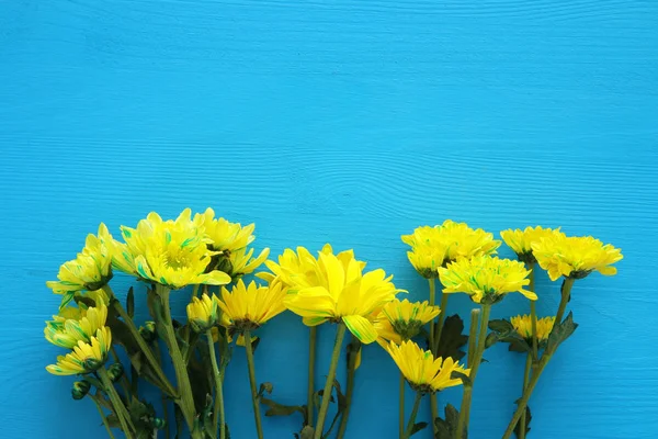 Mavi ahşap arka plan üzerinde hassas sarı çiçek aranjman. Kopya alanı — Stok fotoğraf