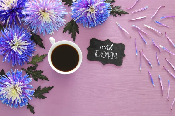 Kopp kaffe och vackra blå blommor arrangemang — Stockfoto