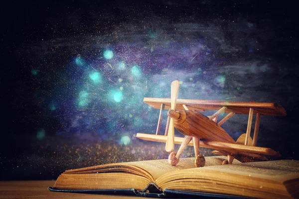 Hračky letadla a otevřená kniha na dřevěný stůl. — Stock fotografie
