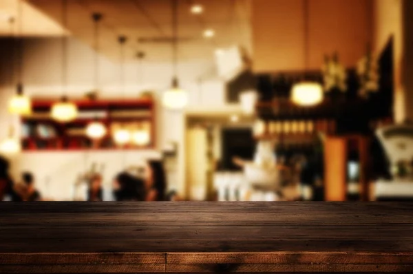 Wooden table in front of abstract blurred restaurant lights — Stock Photo, Image