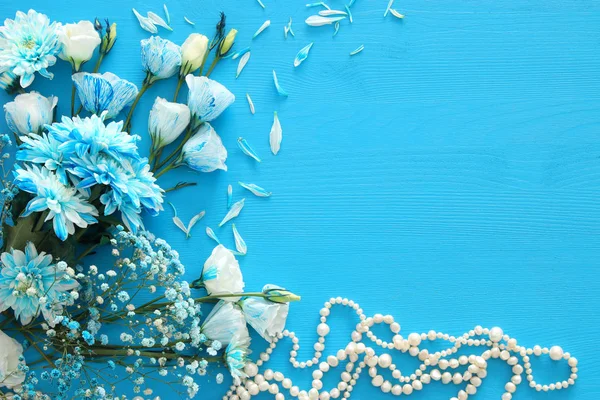 Vista dall'alto di bella e delicata disposizione di fiori blu accanto alla collana di perle — Foto Stock