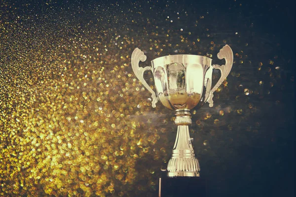 Imagem chave baixa do troféu sobre a mesa de madeira e fundo escuro — Fotografia de Stock