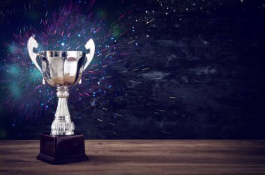 düşük anahtar görüntü Trophy üzerinde ahşap masa ve koyu arka plan