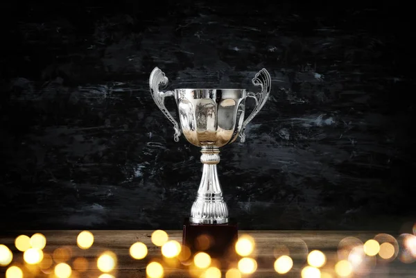 Зображення трофею з низьким ключем над дерев'яним столом і темним тлом — стокове фото