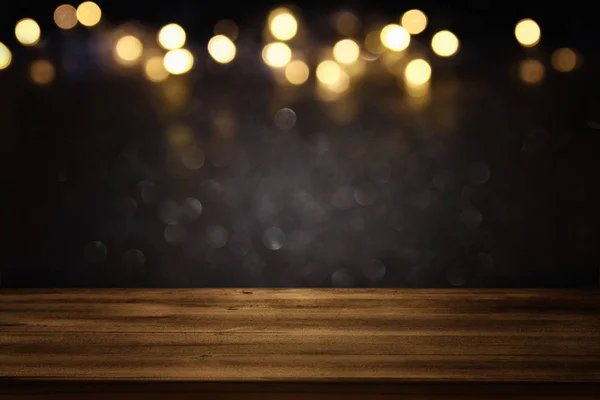 Tavolo vuoto davanti a luci glitter nero e oro sfondo — Foto Stock